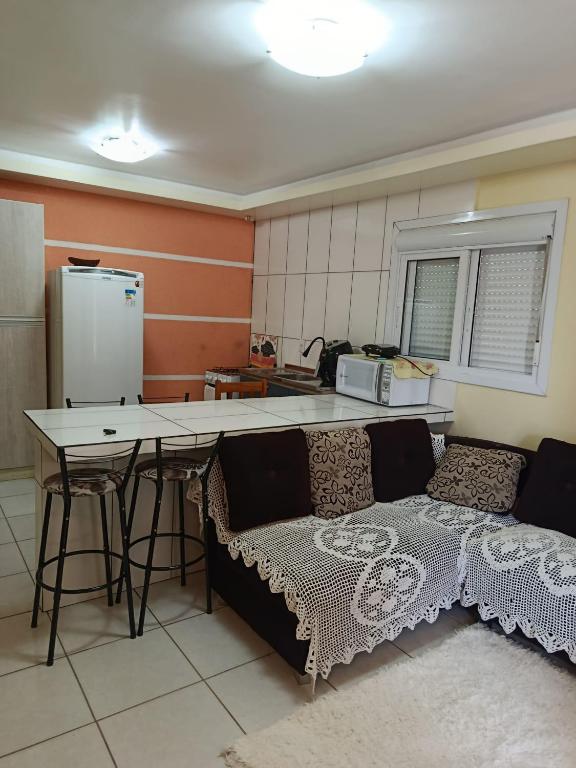 a kitchen with a couch and a table in a room at Casa de 1 quarto in Torres