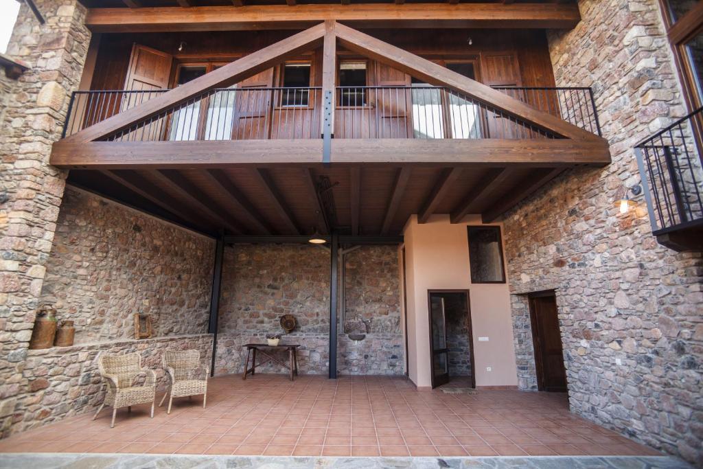 a large stone building with a balcony and a table at El Paller de Casa Parramon in Peramea