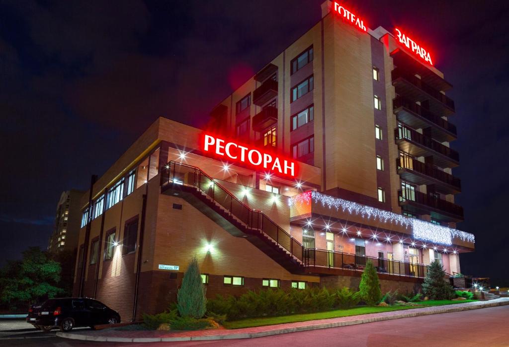 a hotel building with a red neon sign on it at Zagrava Hotel in Dnipro