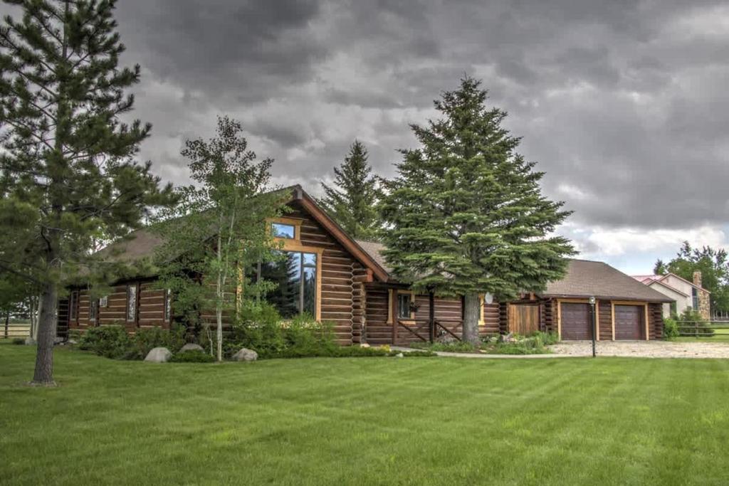 a log cabin with a large yard and trees at Grizzly Peak Cabin in Red Lodge