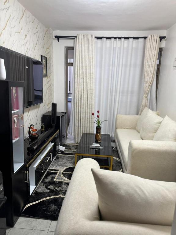 a living room with a couch and a tv at Neriah Paradise in Gatunga
