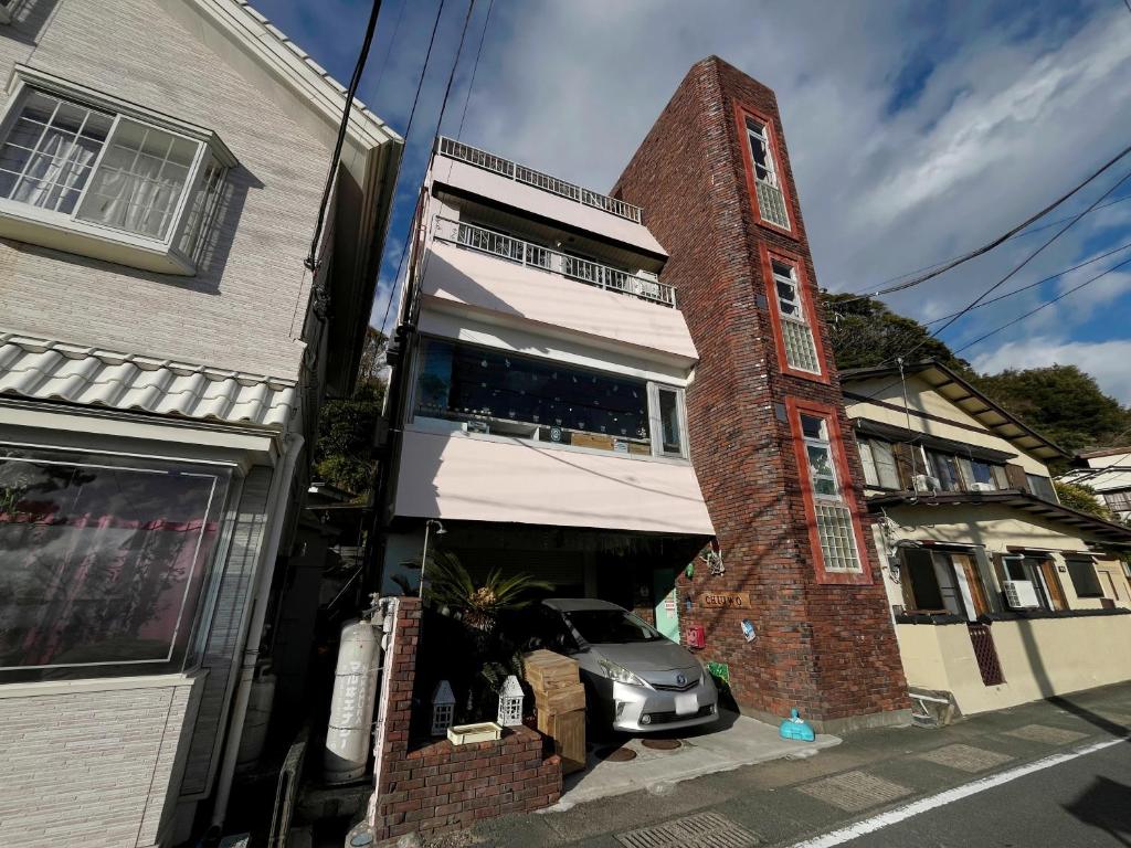 a car parked in the garage of a brick building at ゲストハウス&café chiuwo in Kawazu