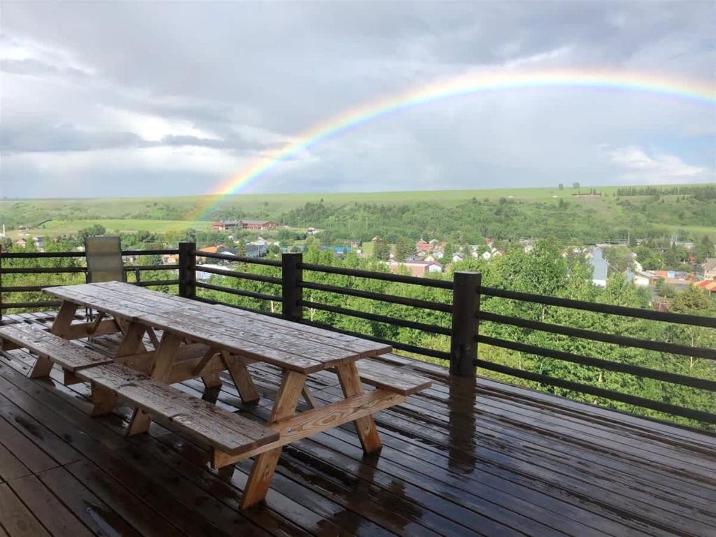 a picnic table with a rainbow in the background at Spruce Lodge in Red Lodge
