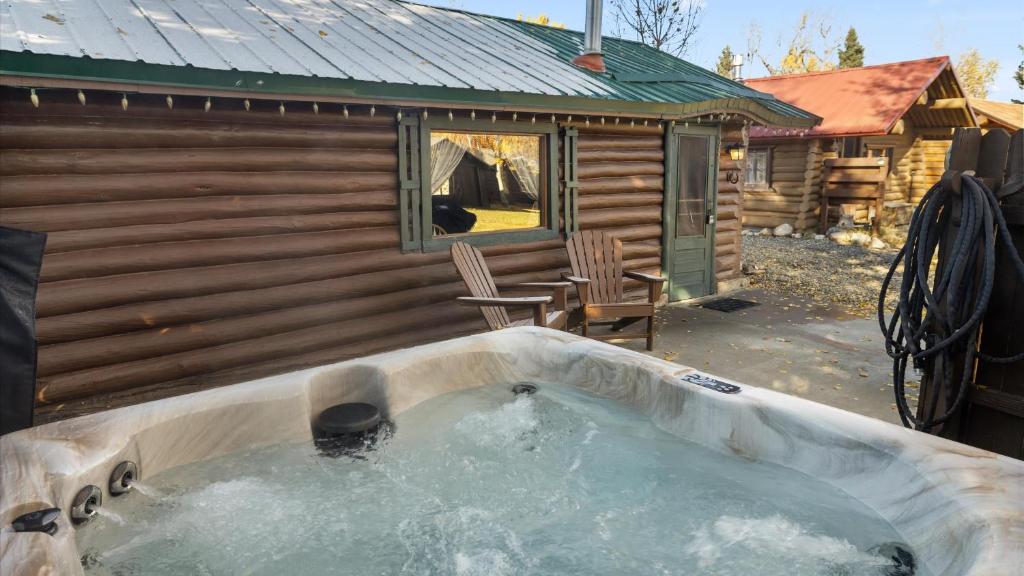 a hot tub in front of a log cabin at Wild Bills Cabin in Red Lodge