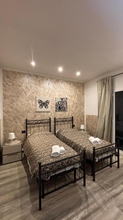 two beds are in a room with at Affittacamere Casa Lucia in La Spezia