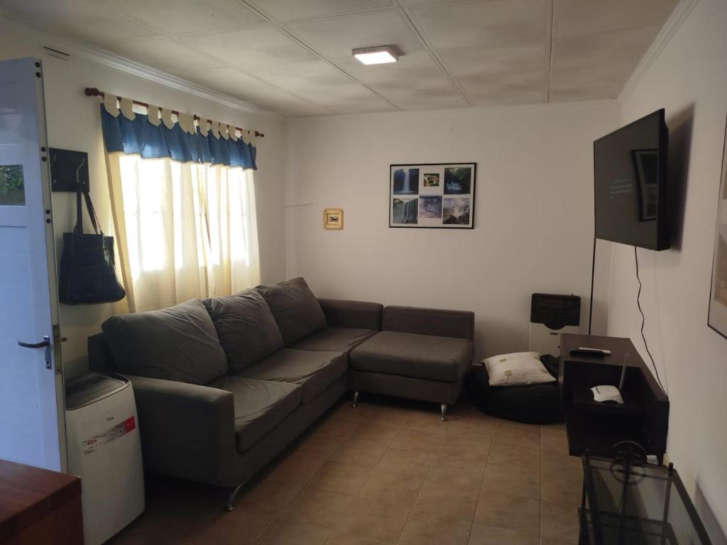 a living room with a couch and a television at Casita de descanso in Pueblo Esther