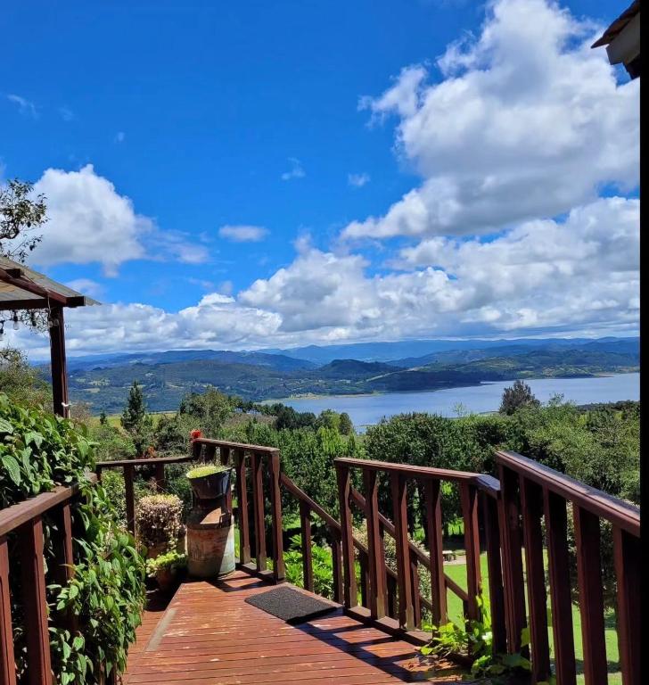 a wooden deck with a view of a lake at Eclipse de luna Guatavita in Guatavita
