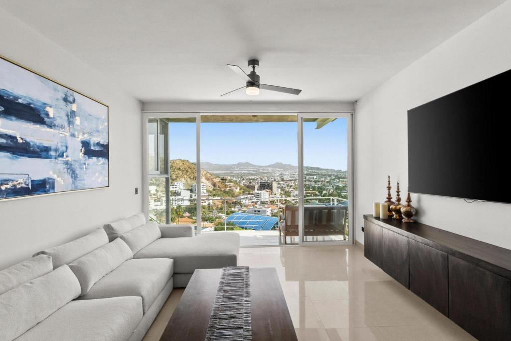 a living room with a couch and a flat screen tv at Casa del Vistas Pedregal in Cabo San Lucas