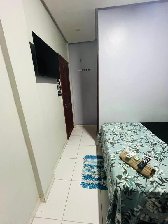 a small bedroom with a bed and a tiled floor at Hotel Big Burg in Breves