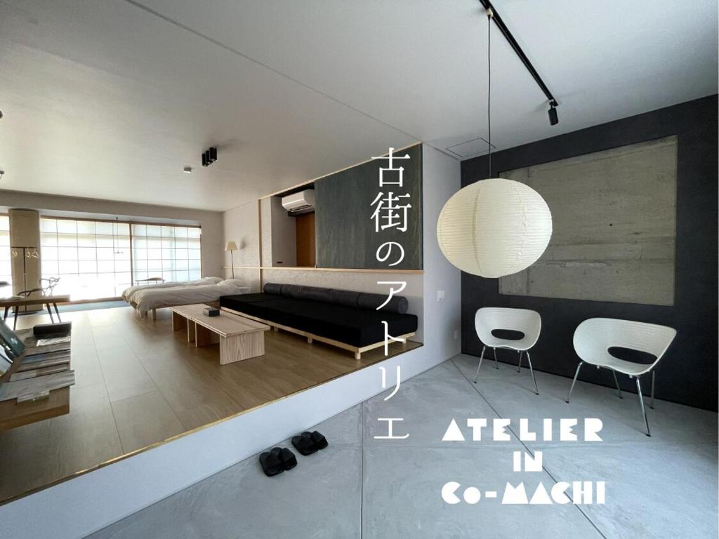 a living room with a black couch and chairs at 古街のアトリエ in Utazu