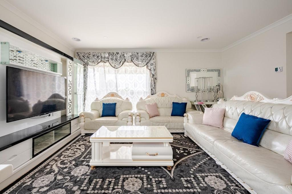 a living room with a couch and a tv at Neat and tidy house in Cranbourne