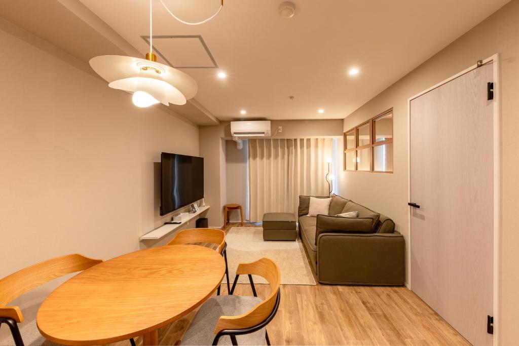 a living room with a table and a couch at The Residence Sapporo - すすきの駅から徒歩6分 - in Sapporo