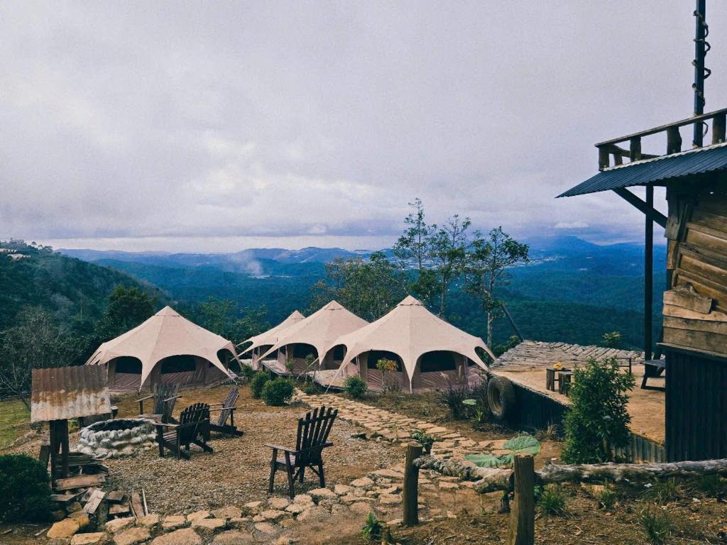 a group of four white tents on top of a mountain at An House in Xuân Trường