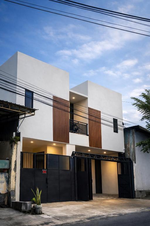 a white house with black doors and windows at Diponegoro House Solo Baru in Solo