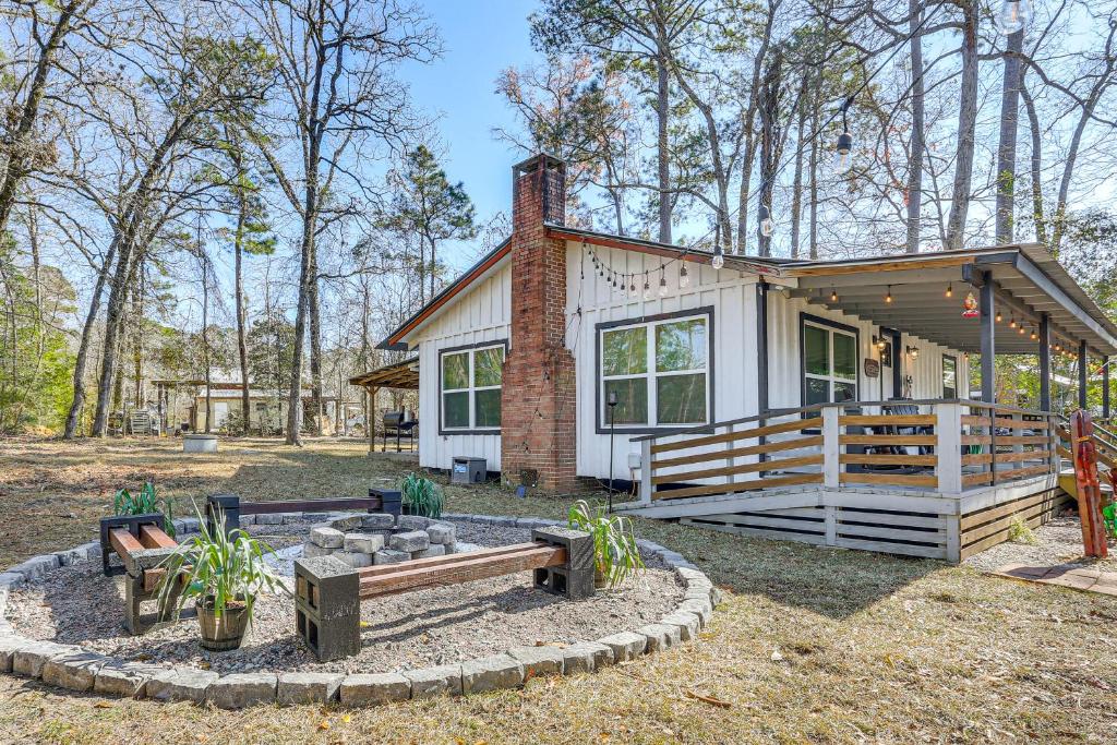 a small house with a fire pit in front of it at Fish Sam Rayburn! Secluded Cabin w/ Deck & Grill in Brookeland