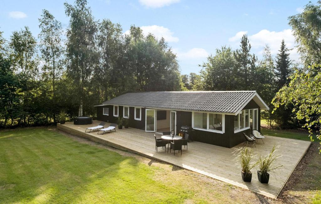 a small house with a deck in a yard at Nice Home In Farsø With House A Panoramic View in Farsø