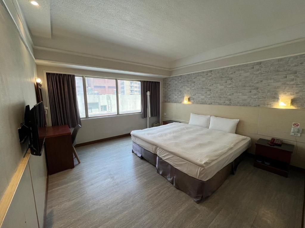 a hotel room with a bed and a television at Long Siang Hotel in Kaohsiung