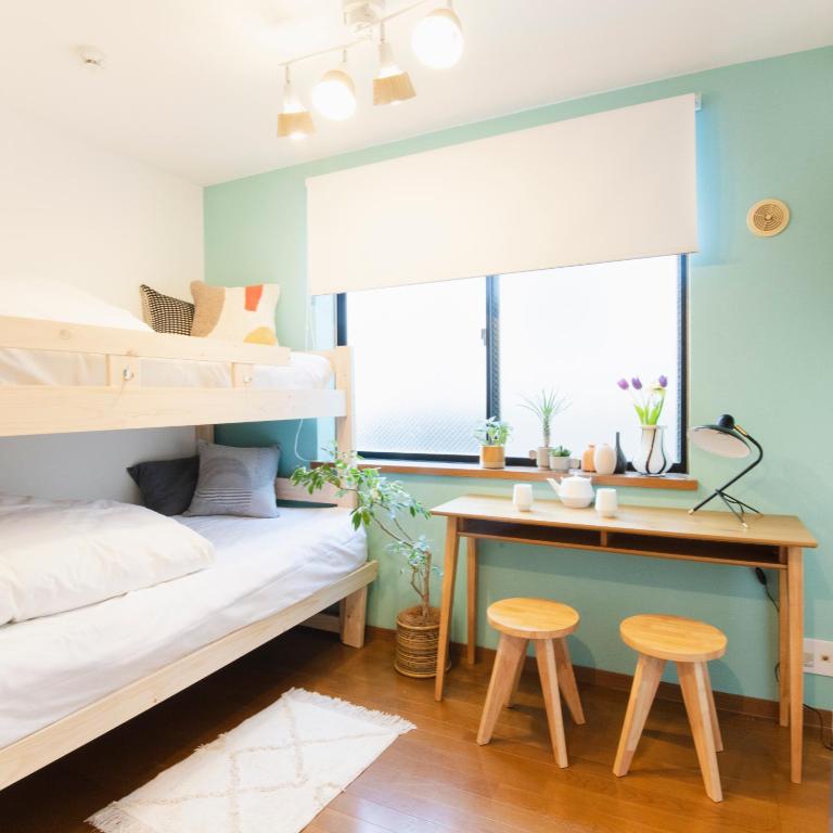 a bedroom with a bunk bed with a desk and two stools at Near Ikebukuro, Kitchen & Laundry, Fast Wi-Fi, 4min to Station,Many restaurants nearby!! in Tokyo