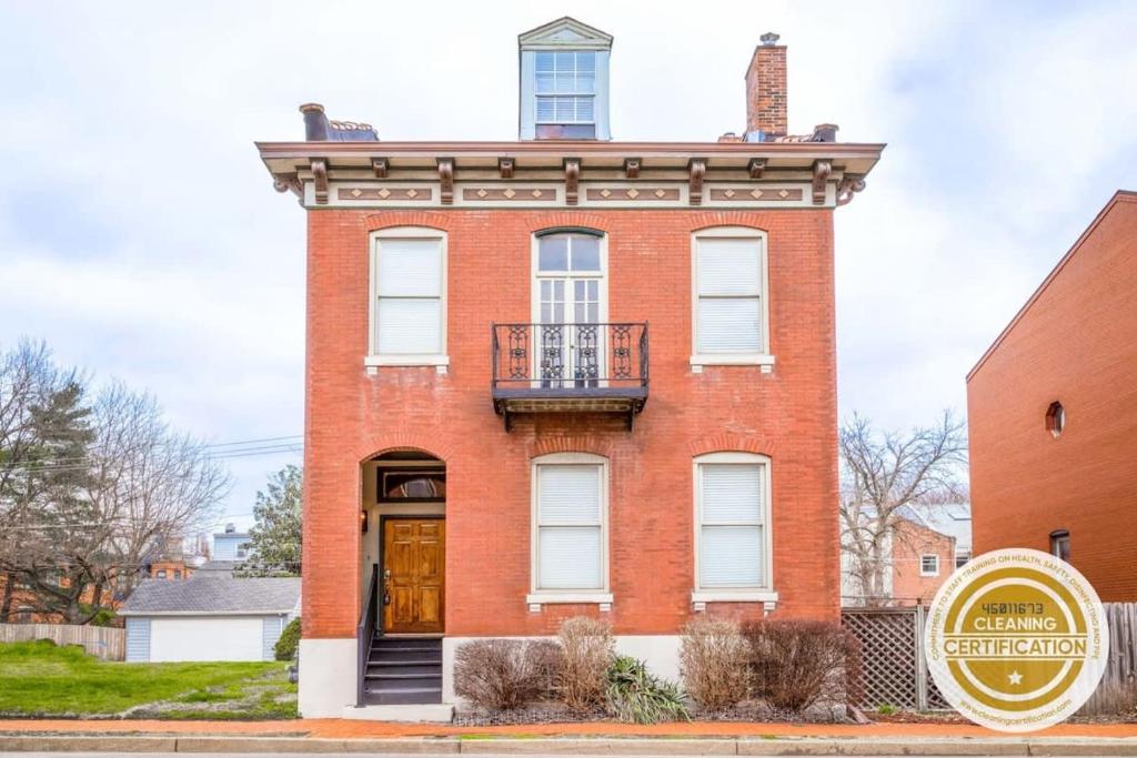 a red brick building with a balcony on it at Spacious Haven near Busch ABODEbucks in Soulard