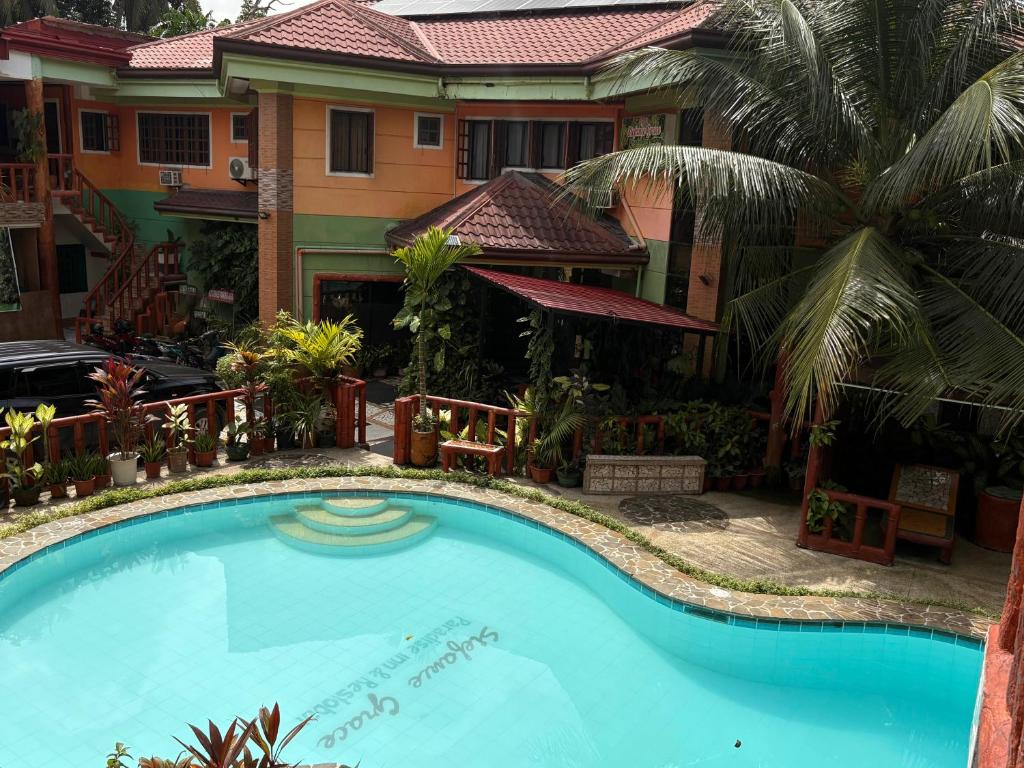 a swimming pool in front of a house at Stefanie Grace Inn in Loboc