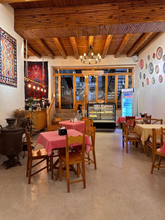 a dining room with tables and chairs in a restaurant at Sarrafon Guest House in Bukhara