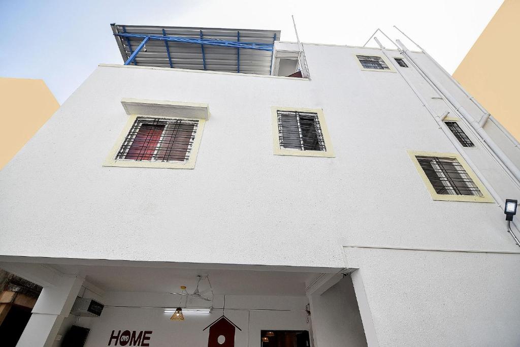 a white building with windows on top of it at HOTEL O THE G STAY in Chinchwad