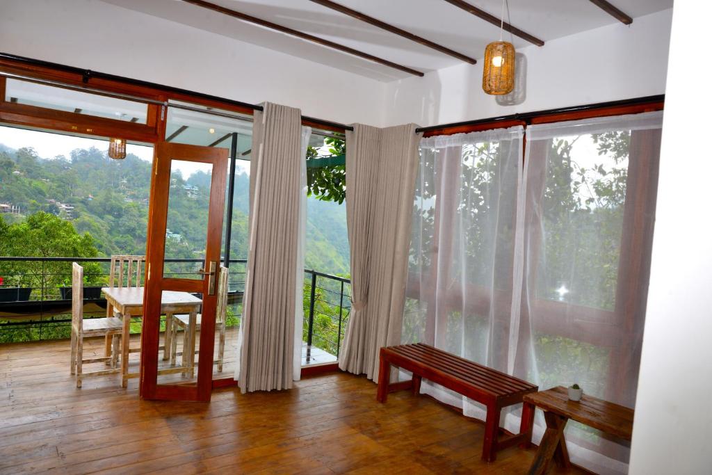 a room with a balcony with large windows and a bench at Bethel Ella in Ella