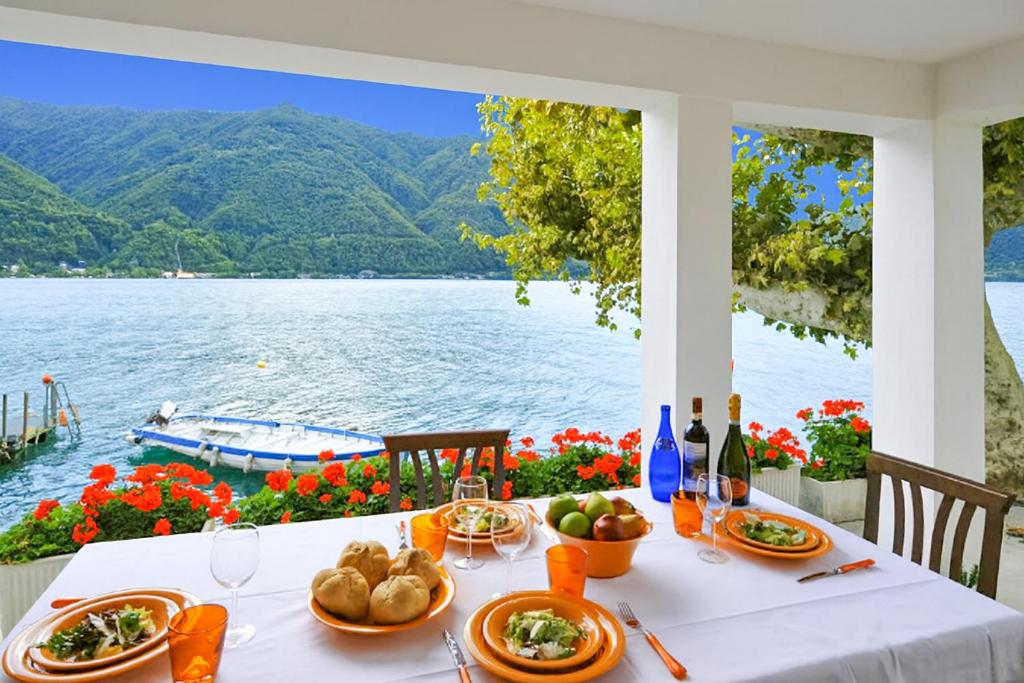 a table with food and a view of the water at Villa L'Approdo in Porlezza