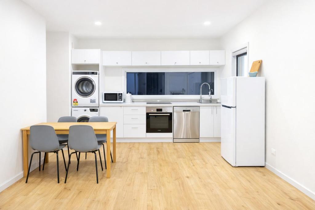 a kitchen with a table and a white refrigerator at Cosy Granny flat in Epping in Epping