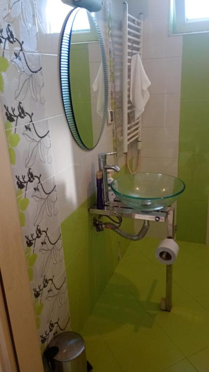 a bathroom with a green sink and a mirror at Кичук Париж in Plovdiv