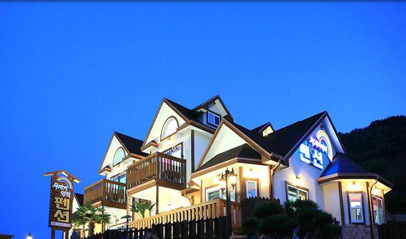 a large white house with a sign in front of it at Rainbow Hill Pension in Namhae