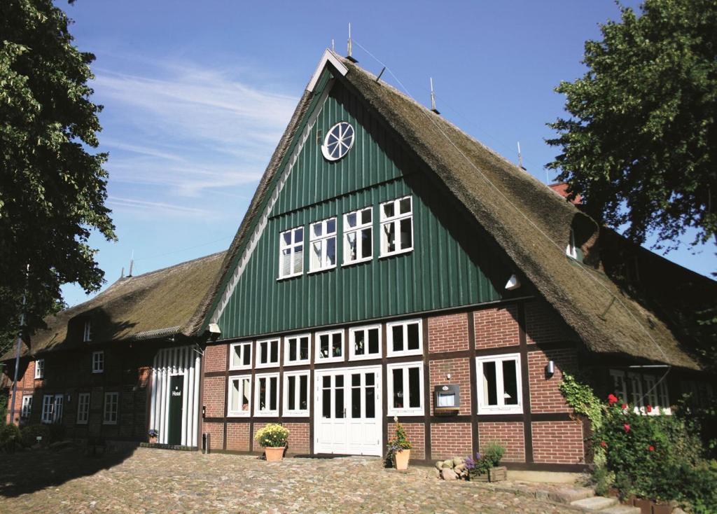 a green and white building with a thatched roof at Fischerwiege am Passader See in Passade