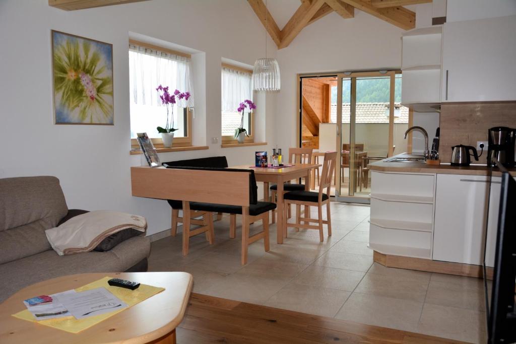 a kitchen and living room with a couch and a table at Privatpension Bergkristall in San Martino