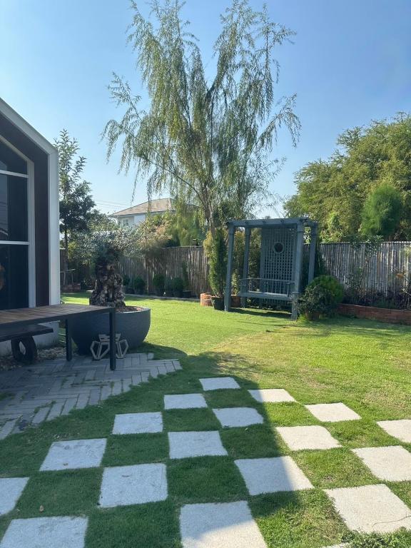 a garden with a bench and a playground at 20 Tree Ville in Ban Ko