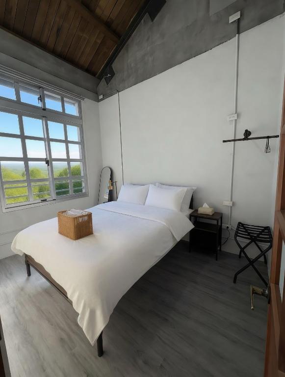 a large white bed in a room with a large window at 未半文旅 in Yilan City