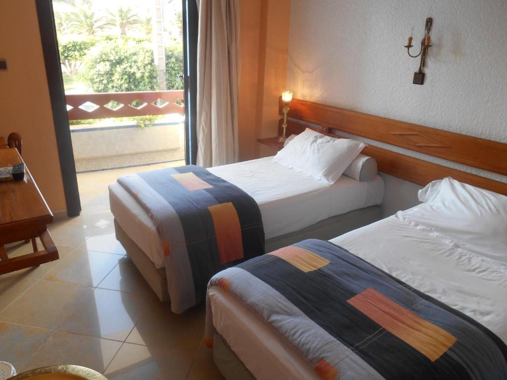 Cette chambre comprend 2 lits et une fenêtre. dans l'établissement Hotel Babel, à Nador
