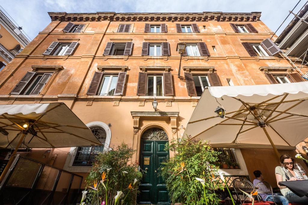 un edificio con una porta verde e due ombrelloni davanti di Casa De' Fiori a Roma