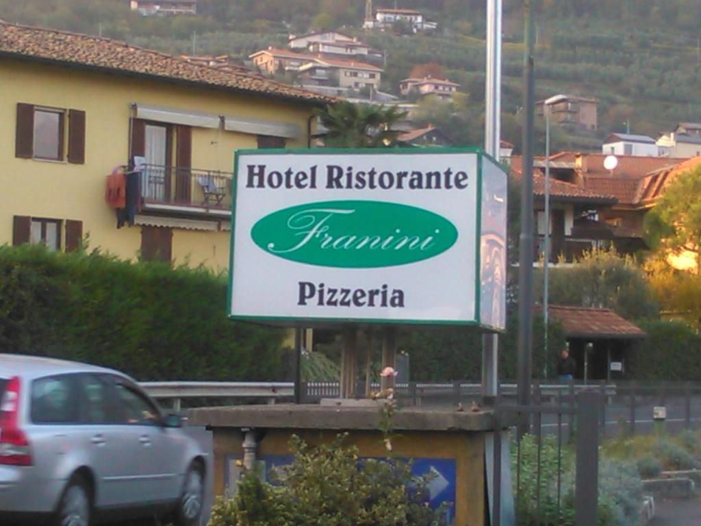 un cartello per un ristorante di un hotel di fronte a un edificio di Hotel Franini a Costa Volpino