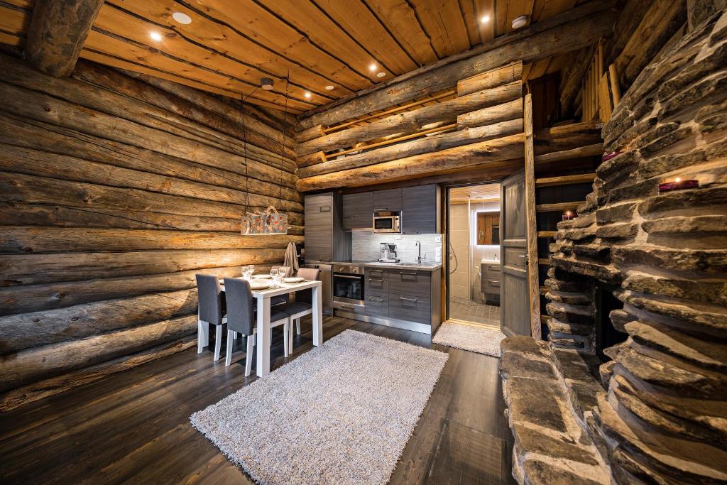 a kitchen in a log cabin with a table and chairs at UnelmaPovi in Ruka