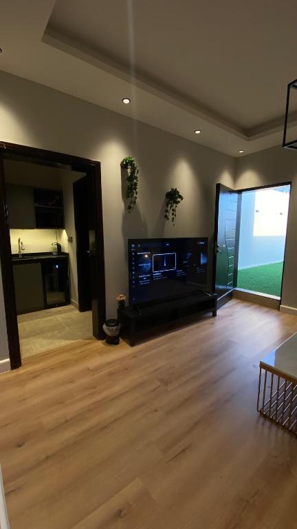a living room with a flat screen tv and a wooden floor at Cozy privet unit شقة وحيدة وهادئة in Riyadh