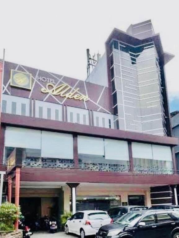 a building with cars parked in front of it at Hotel Alden in Makassar