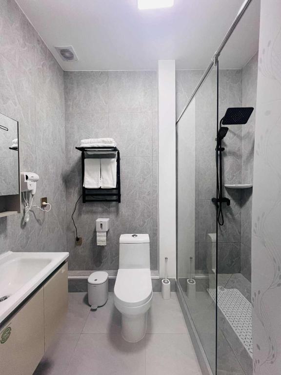 a bathroom with a toilet and a sink and a shower at Och Service Apartment in Ulaanbaatar