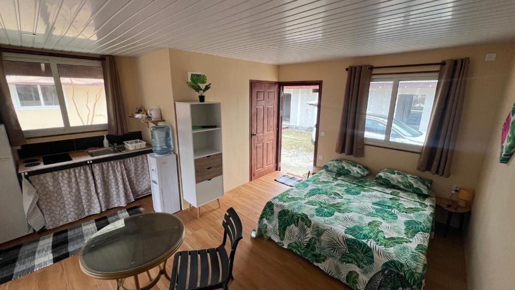 a bedroom with a bed and a table and chairs at Hiti Village G2 in Tikehau Airport
