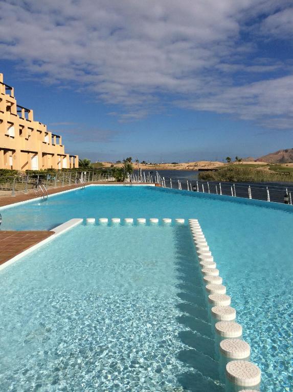 a large swimming pool with a hotel in the background at Las Islas de Terrazas de la torre in Roldán