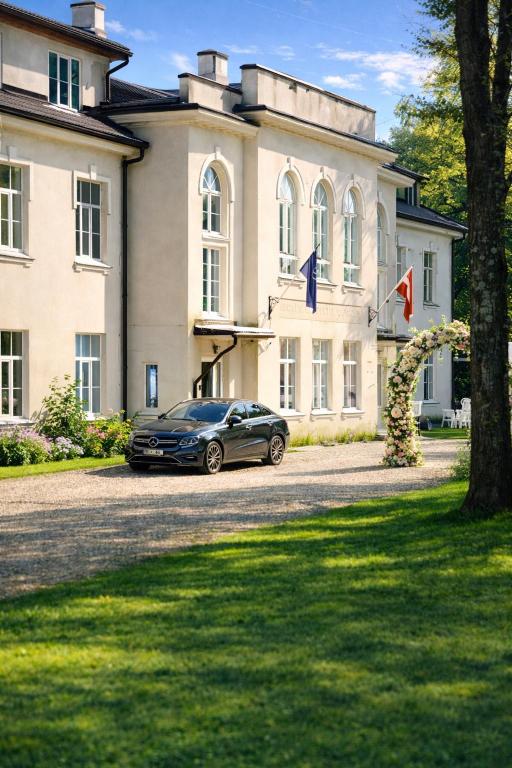 a car parked in front of a building at Viesnīca Meirānu Muiža in Meirāni