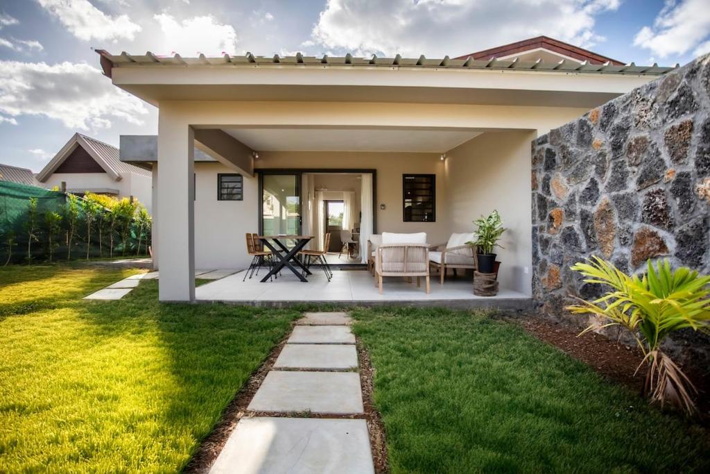 a patio of a home with a stone wall at Salty Sands Studio in Rivière Noire