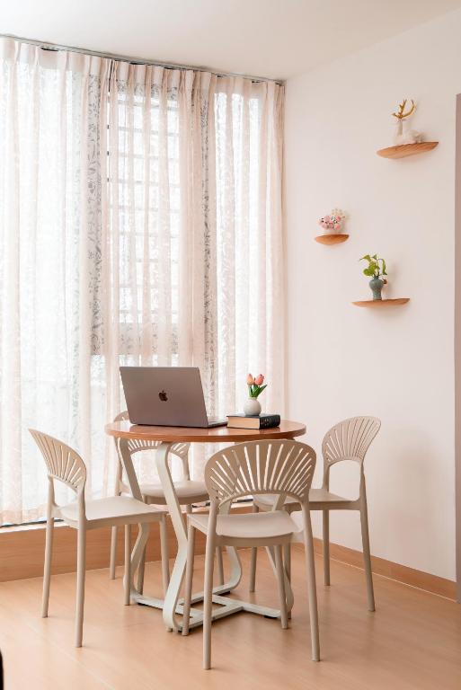 a dining room table with a laptop computer on it at Man Man hotel in Wutongkeng