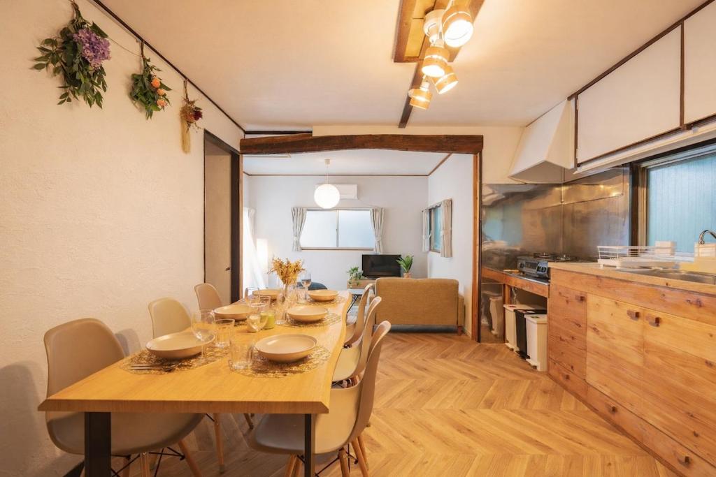 a dining room with a table and a kitchen at Yokosuka Guest House in Yokosuka