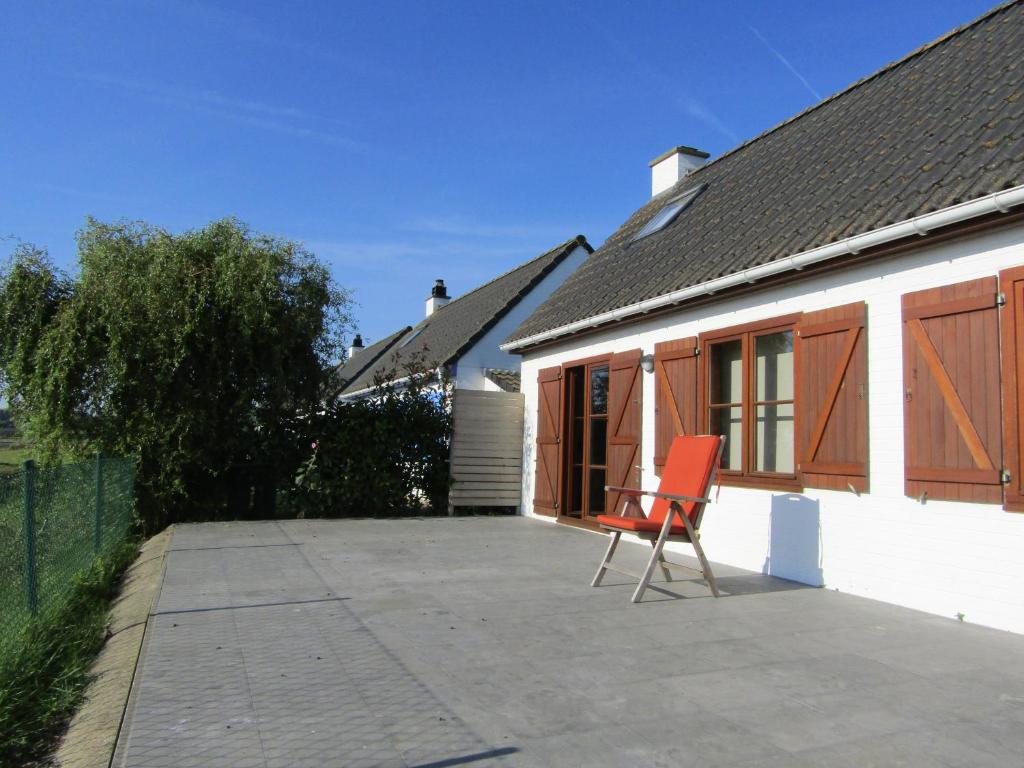una silla en un patio junto a una casa en Nieuwendamme 14, en Nieuwpoort
