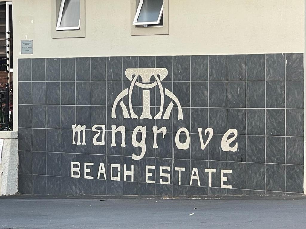 a sign for a beach estate with a spider on it at Mangrove Beach Estate Boboyi in Port Shepstone